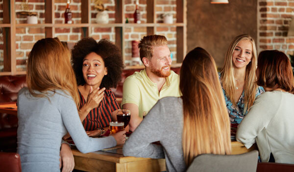 Group Of Friends Having Dinner At Restaurant. Friends Cheering A